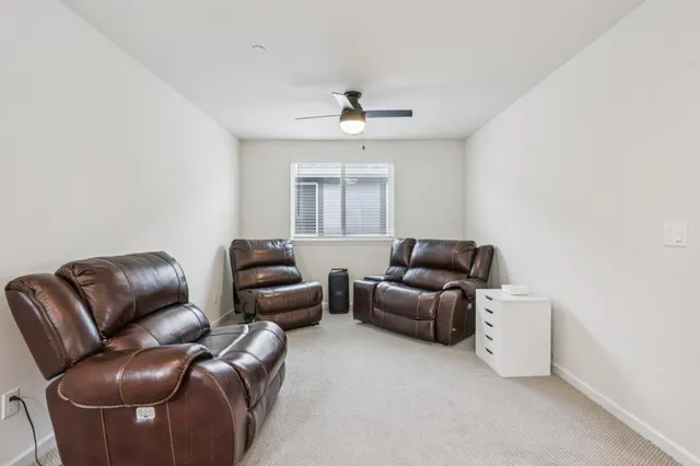 a living room with furniture and a ceiling fan