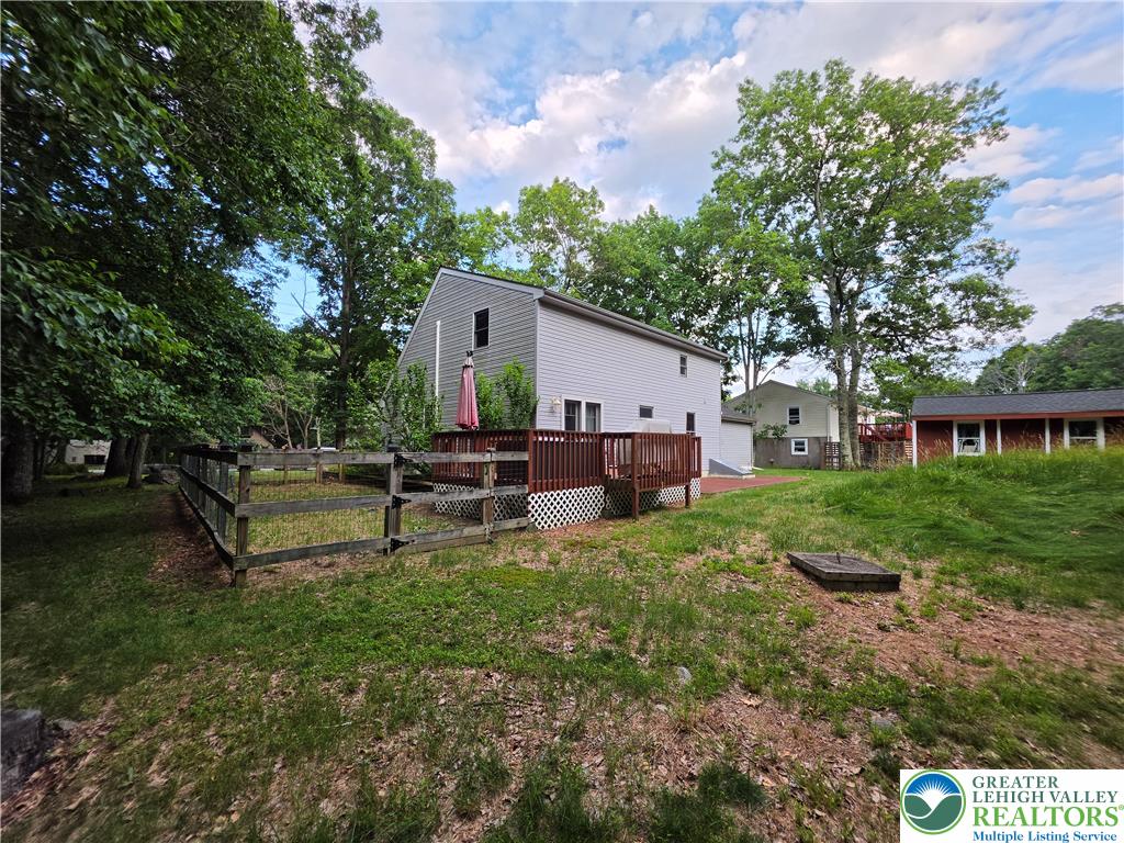 211 Murphy Circle Bushkill, PA 18324 - Photo 25 of 28 A fenced backyard offers a private outdoor retreat with a spacious deck, ideal for relaxation and gatherings.