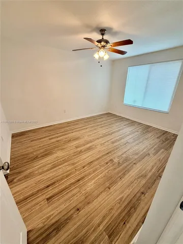 a view of a room with wooden floor and fan