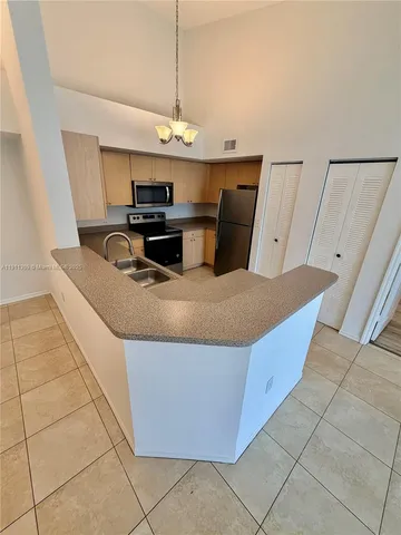 a kitchen with stainless steel appliances granite countertop a sink a counter space and cabinets