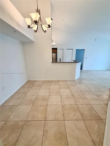 a view of empty room with a kitchen