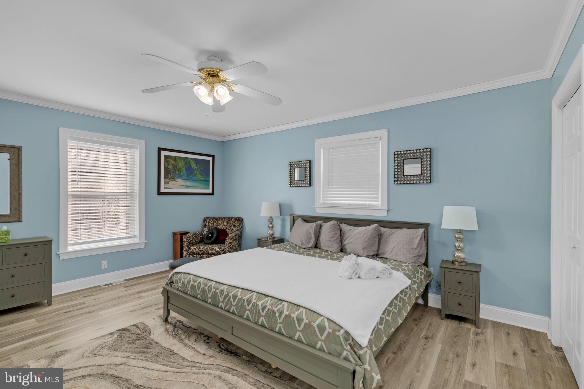 1887 Point Breeze Road Hudgins, VA 23076 - Photo 61 of 77 a spacious bedroom with a bed a chandelier and a window