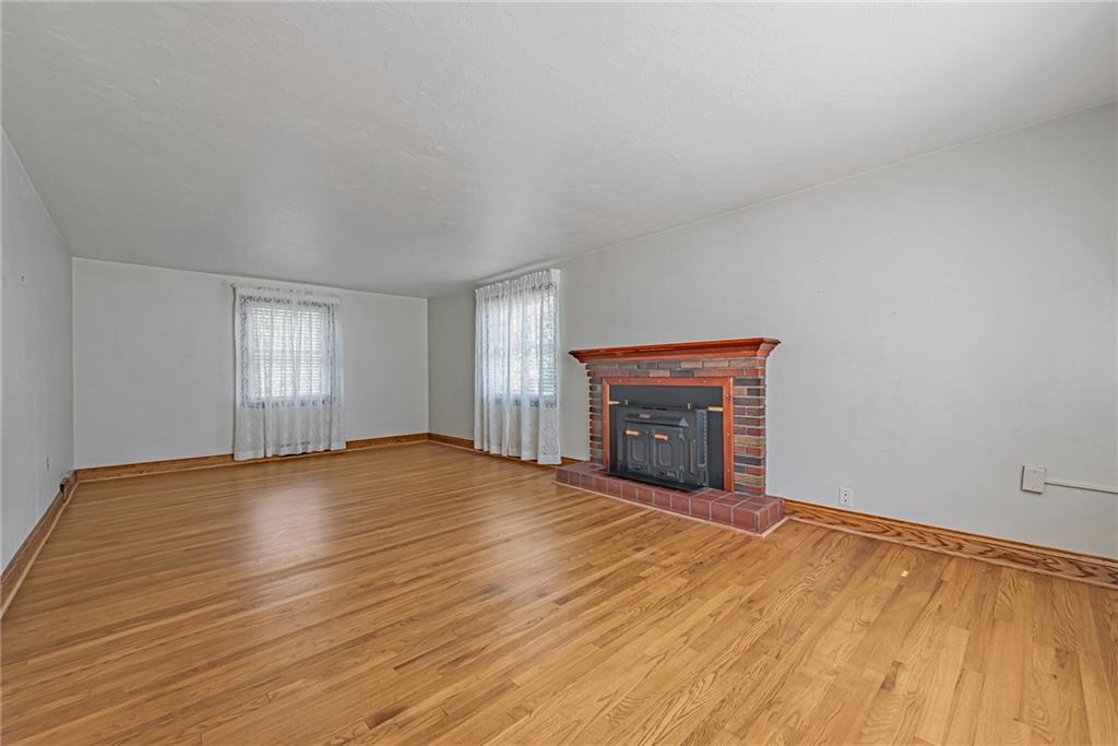 1431 New Stanton Ruffsdale Road Ruffs Dale, PA 15679 - Photo 3 of 25 an empty room with wooden floor and fireplace