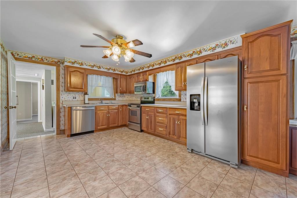 1431 New Stanton Ruffsdale Road Ruffs Dale, PA 15679 - Photo 7 of 25 a kitchen with stainless steel appliances granite countertop a refrigerator a sink dishwasher and a refrigerator with wooden floor