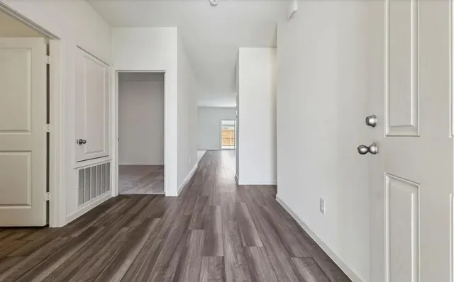 a view of a hallway with wooden floor and staircase