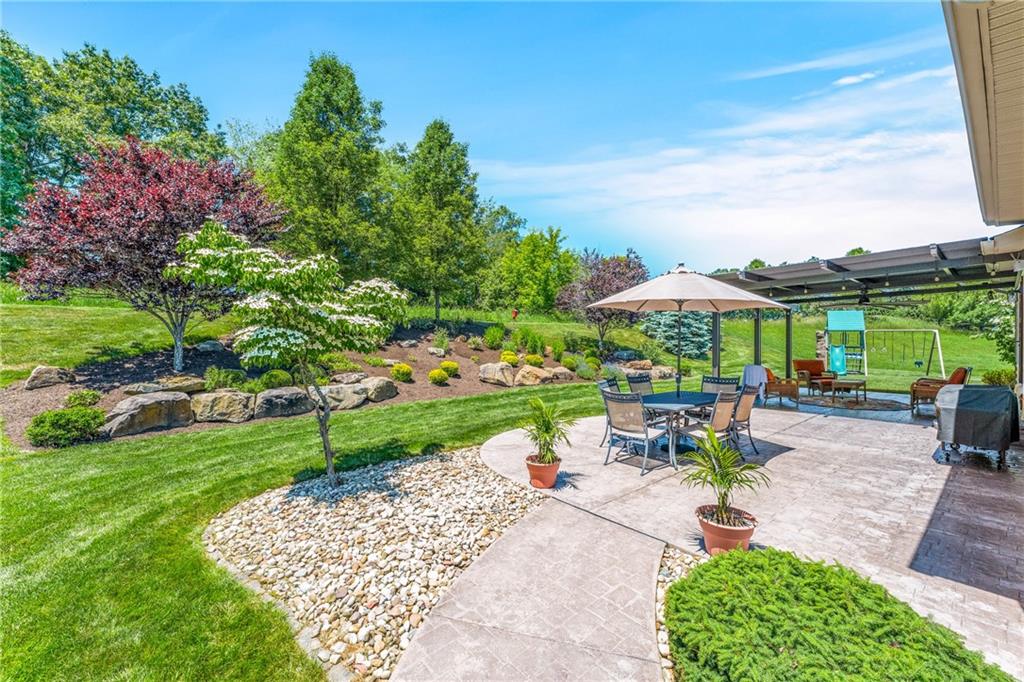 211 Taylor Ridge Lane Mars, PA 16046 - Photo 22 of 50 a view of a patio with a table and chairs under an umbrella