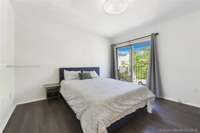 a large bed sitting in a bedroom next to a window