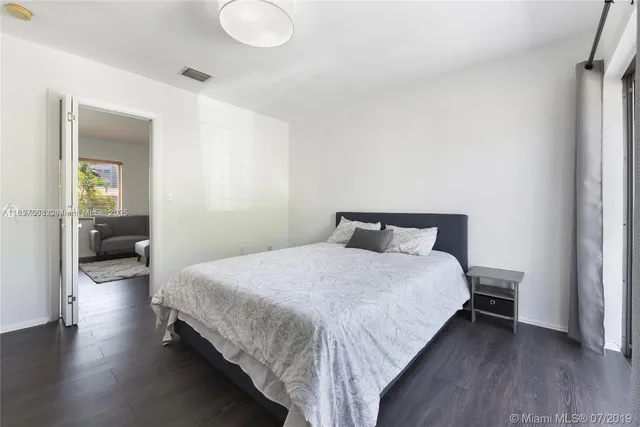 a bedroom with a bed and view of living room