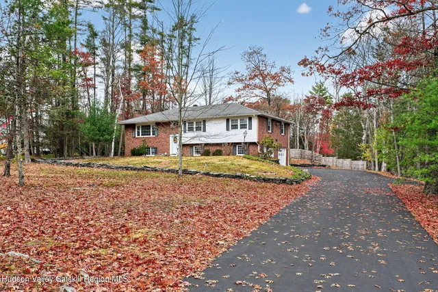 a front view of a house with a yard and trees