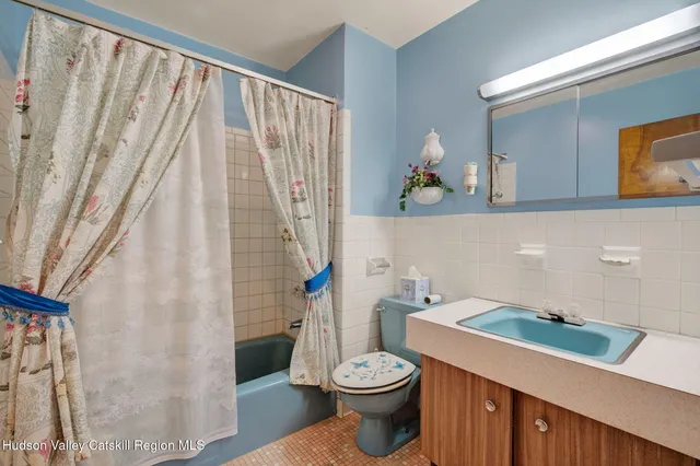 a bathroom with a toilet a sink and a mirror