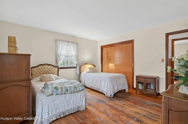 a bedroom with two beds and painting on the wall