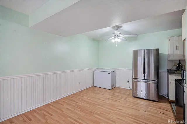 a kitchen with granite countertop a refrigerator and a ceiling fan