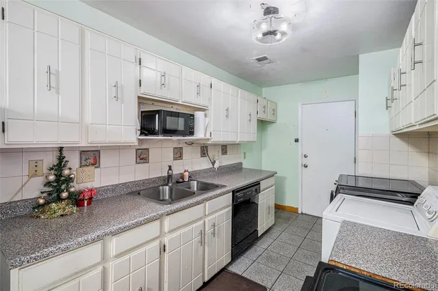 a kitchen with granite countertop a sink stainless steel appliances and cabinets