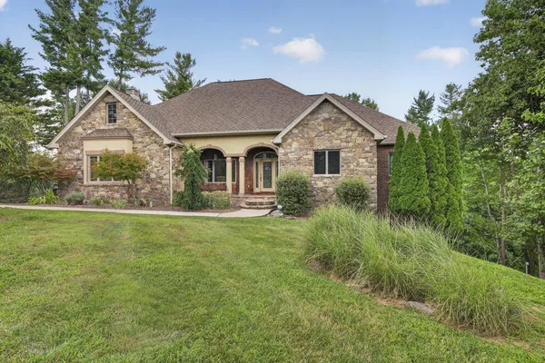 a front view of a house with a yard and potted plants