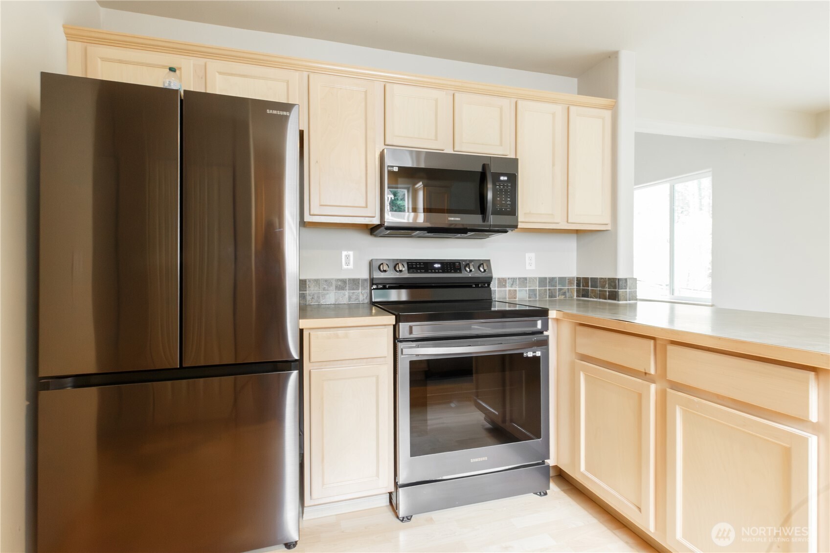 22463 Southeast 244th Street Maple Valley, WA 98038 - Photo 11 of 26 a kitchen with a refrigerator stove and microwave