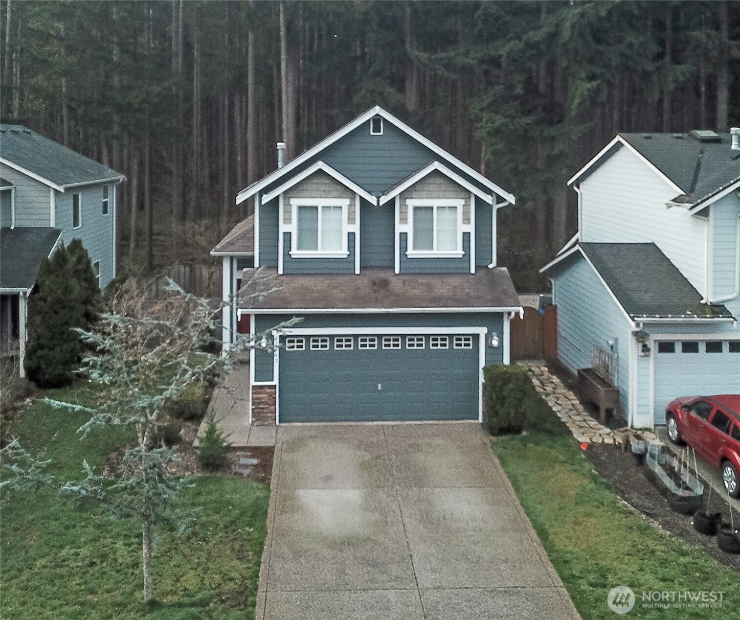 22463 Southeast 244th Street Maple Valley, WA 98038 - Photo 21 of 26 a front view of a house with a yard and garage