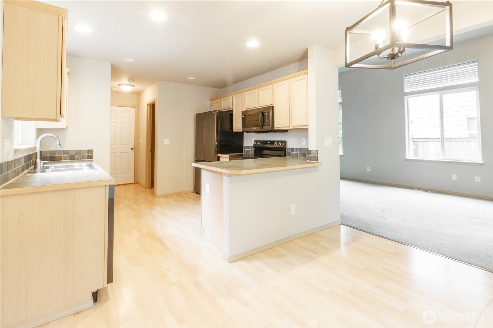 22463 Southeast 244th Street Maple Valley, WA 98038 - Photo 5 of 26 a kitchen with a sink a stove and a refrigerator