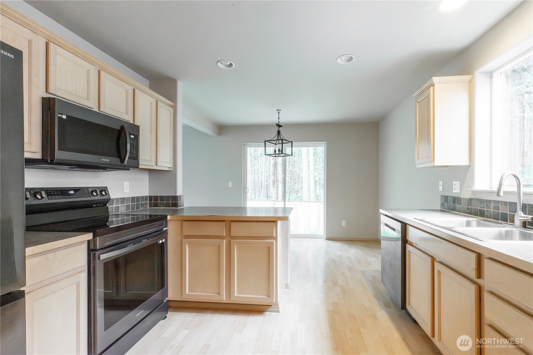 22463 Southeast 244th Street Maple Valley, WA 98038 - Photo 7 of 26 a kitchen with stainless steel appliances a stove sink microwave and cabinets