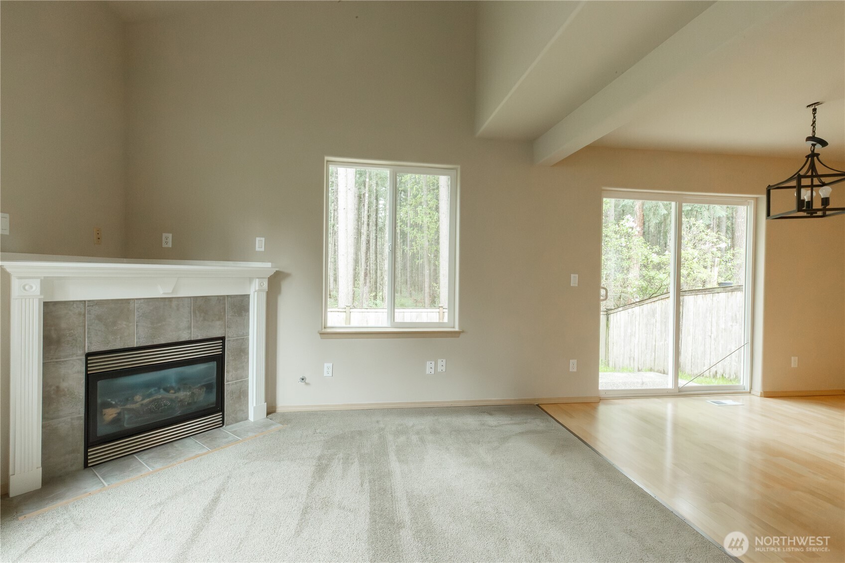 22463 Southeast 244th Street Maple Valley, WA 98038 - Photo 9 of 26 a view of an empty room with a fireplace and a window