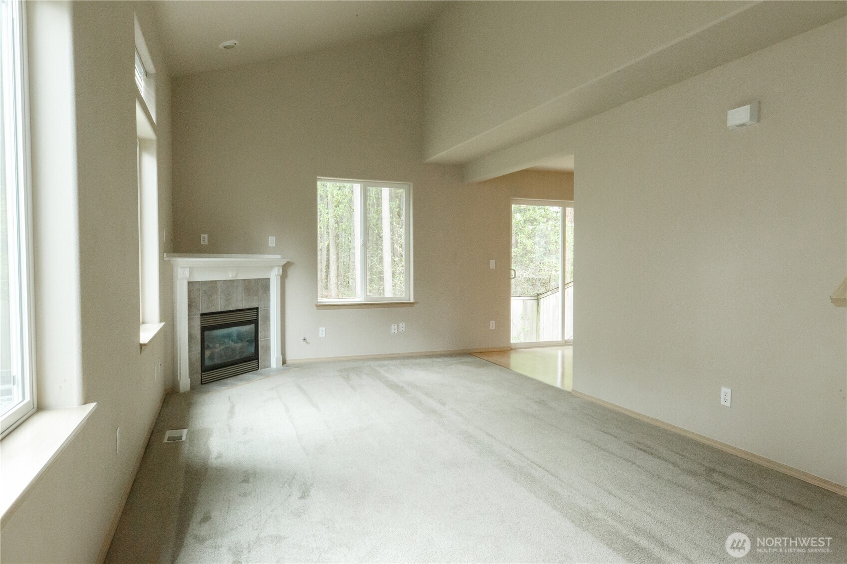 22463 Southeast 244th Street Maple Valley, WA 98038 - Photo 10 of 26 an empty room with fireplace and windows
