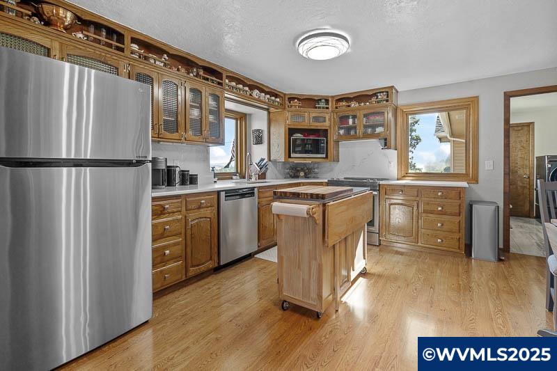 11660 Simpson Road Monmouth, OR 97361 - Photo 11 of 50 a kitchen with stainless steel appliances granite countertop a refrigerator a stove top oven a sink dishwasher and white cabinets with wooden floor