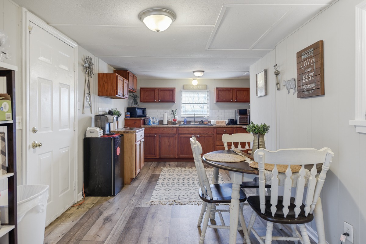6016 Highland Road Orlinda, TN 37141 - Photo 17 of 34 a kitchen with stainless steel appliances granite countertop a refrigerator a stove a sink dishwasher and white cabinets with wooden floor