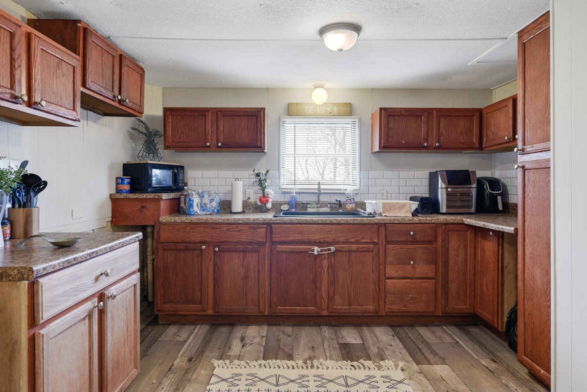 6016 Highland Road Orlinda, TN 37141 - Photo 18 of 34 a kitchen with stainless steel appliances granite countertop wooden cabinets a sink and dishwasher