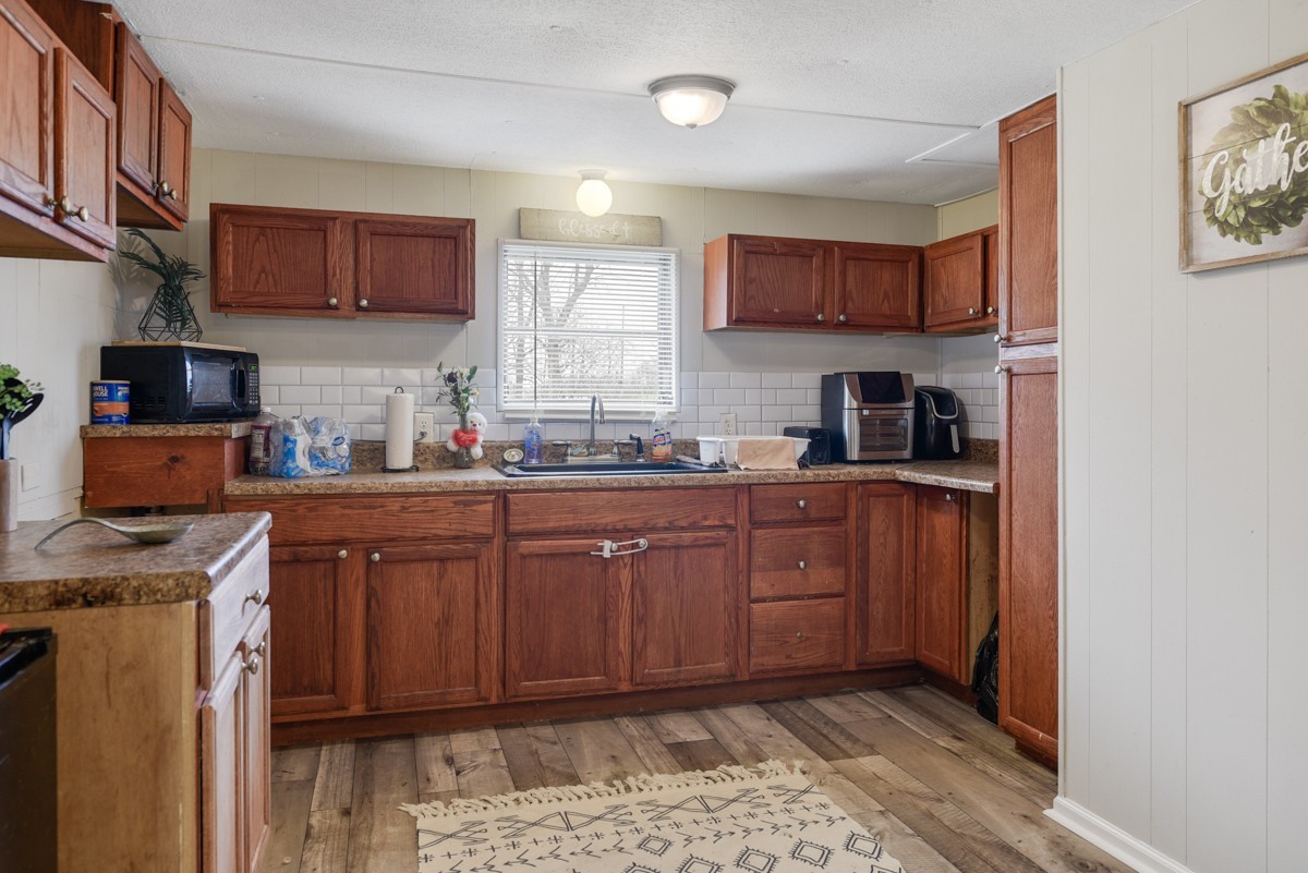 6016 Highland Road Orlinda, TN 37141 - Photo 19 of 34 a kitchen with stainless steel appliances granite countertop a sink stove and cabinets