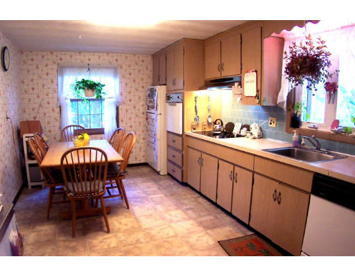 32 Ansie Road Chelmsford, MA 01824 - Photo 4 of 5 a kitchen with stainless steel appliances a dining table chairs and a refrigerator