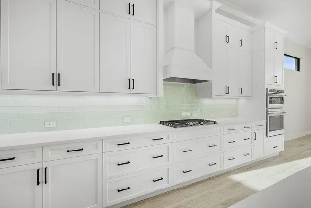 a kitchen with granite countertop white cabinets and white appliances