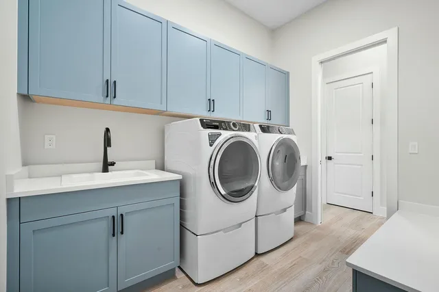 a utility room with sink dryer and washer