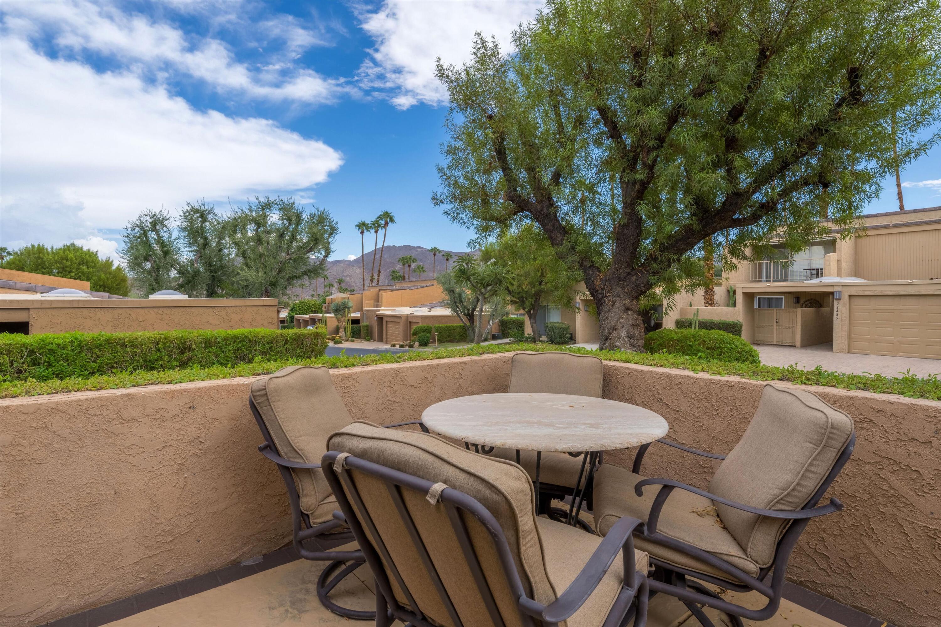 73476 Dalea Lane Palm Desert, CA 92260 - Photo 14 of 37 a view of a patio with table and chairs floor to ceiling window with wooden floor