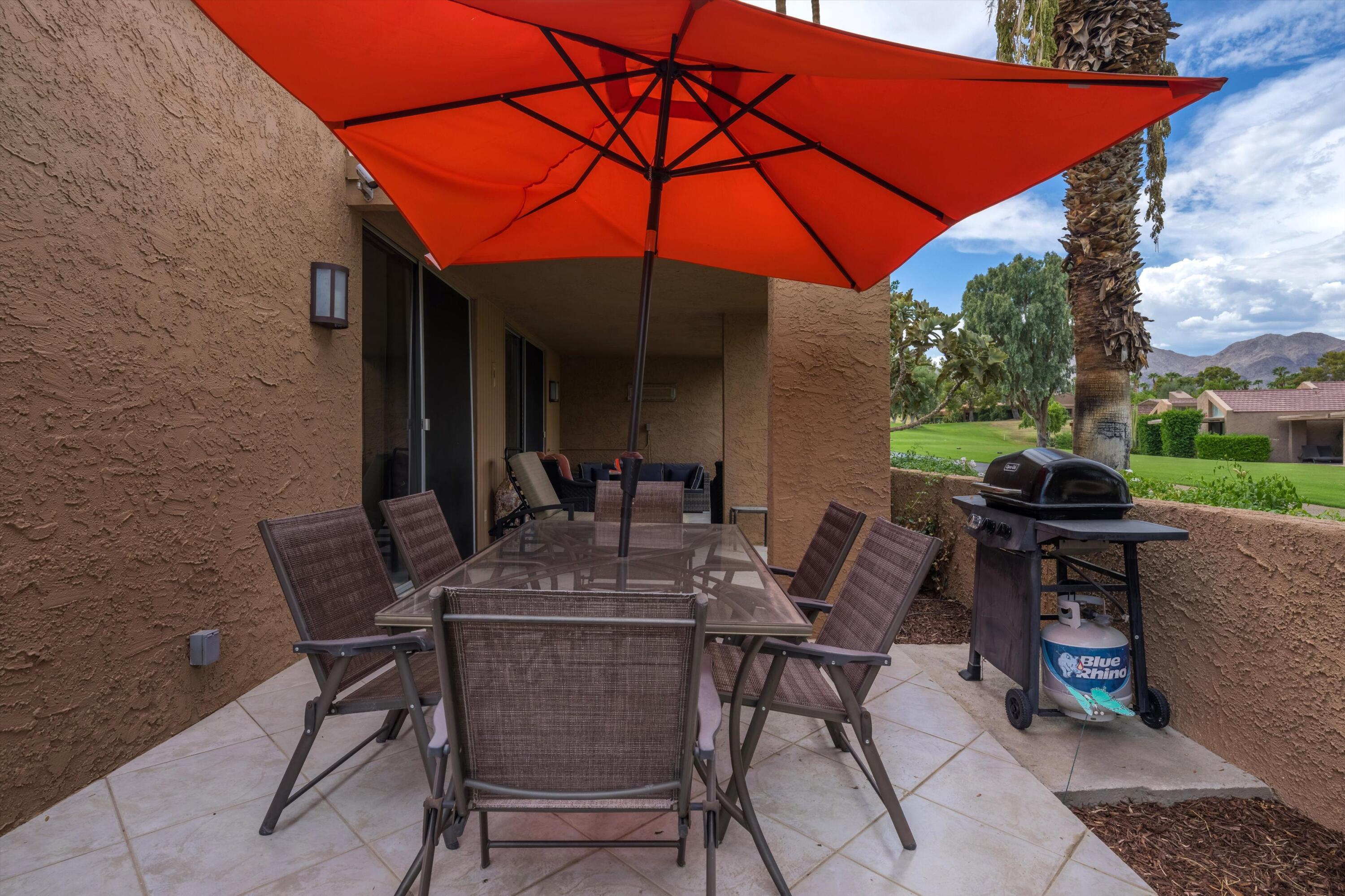 73476 Dalea Lane Palm Desert, CA 92260 - Photo 19 of 37 a view of patio with chairs and table under an umbrella