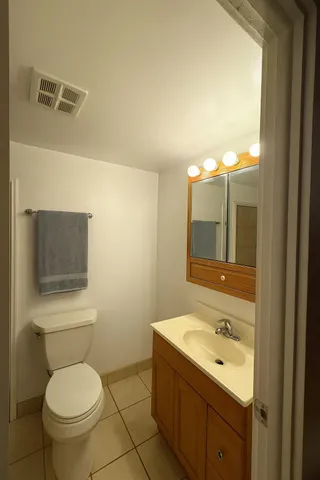 a bathroom with a toilet sink double vanity and mirror
