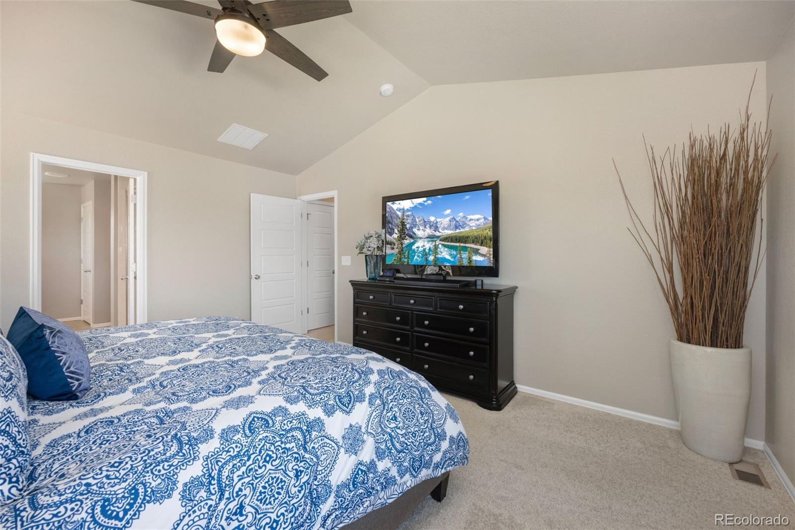 8809 Foxfire Street Firestone, CO 80504 - Photo 19 of 32 a bedroom with a bed and a flat screen tv