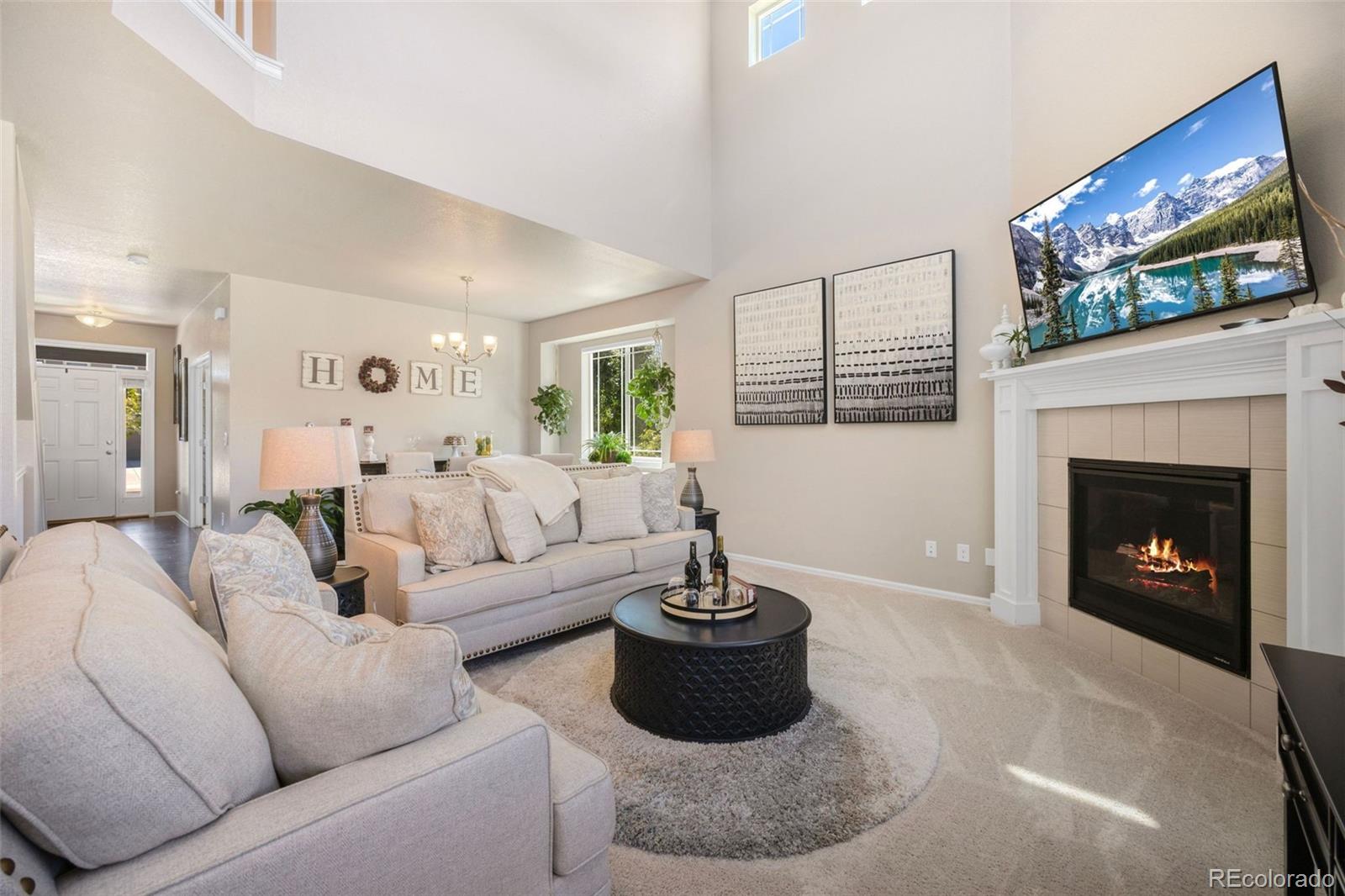 8809 Foxfire Street Firestone, CO 80504 - Photo 8 of 32 a living room with furniture a fireplace and a large mirror