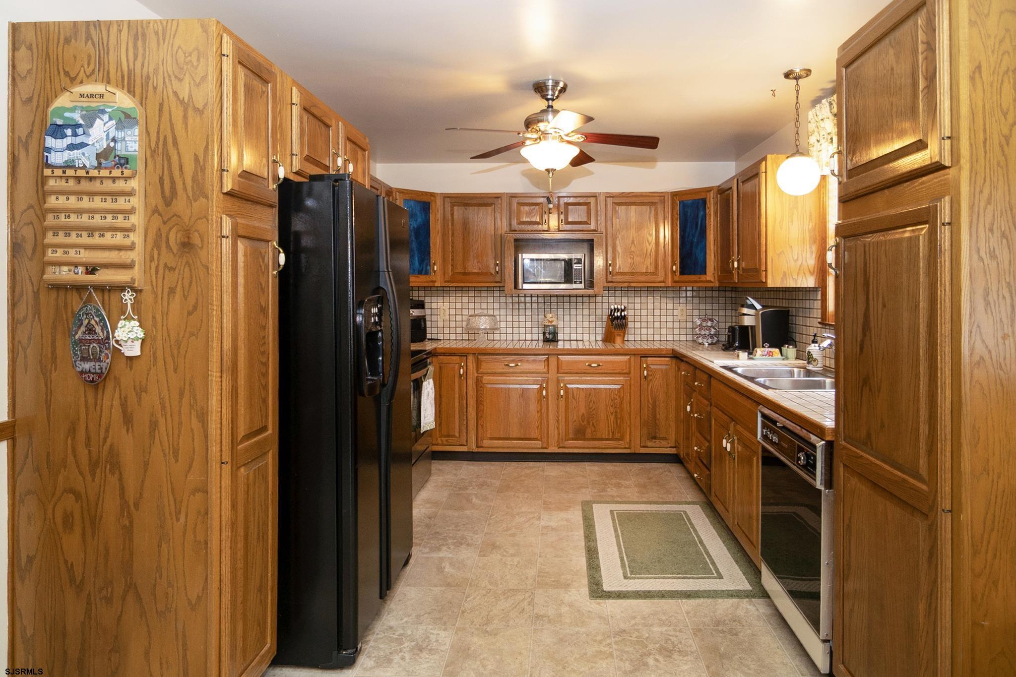 55 Taylor Avenue Milmay, NJ 08340 - Photo 14 of 53 a kitchen with stainless steel appliances granite countertop a refrigerator a sink dishwasher with a dining table and chairs