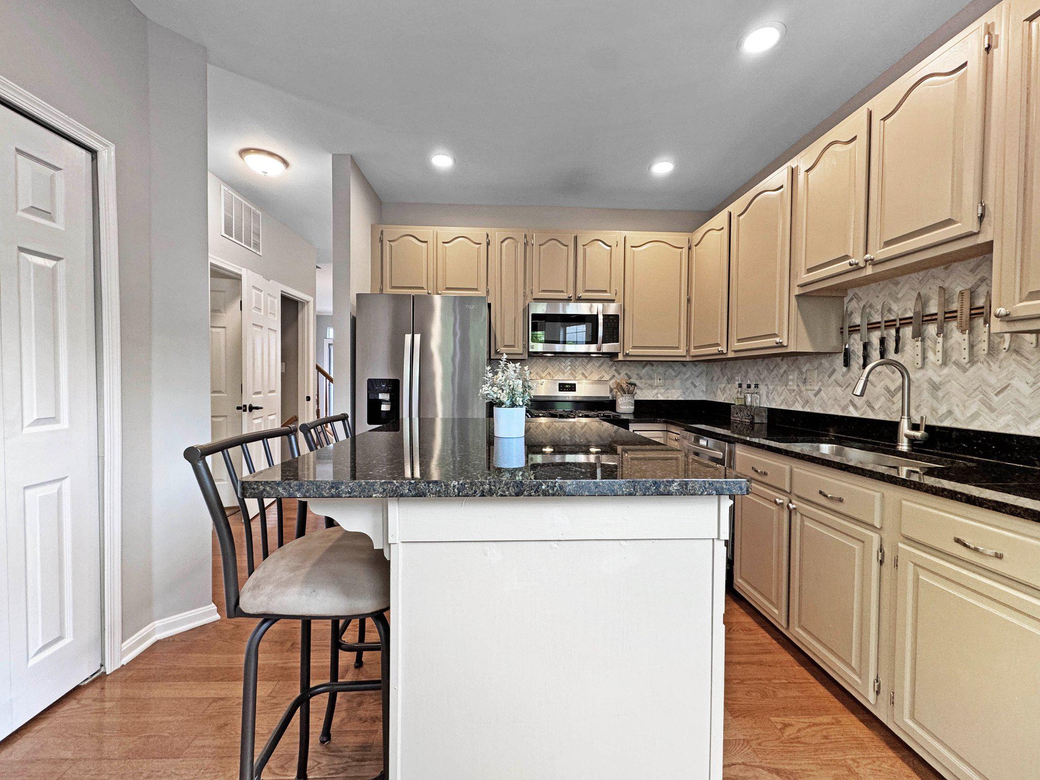 47640 Comer Square Sterling, VA 20165 - Photo 12 of 58 a kitchen with stainless steel appliances granite countertop a stove a sink a microwave a refrigerator and cabinets