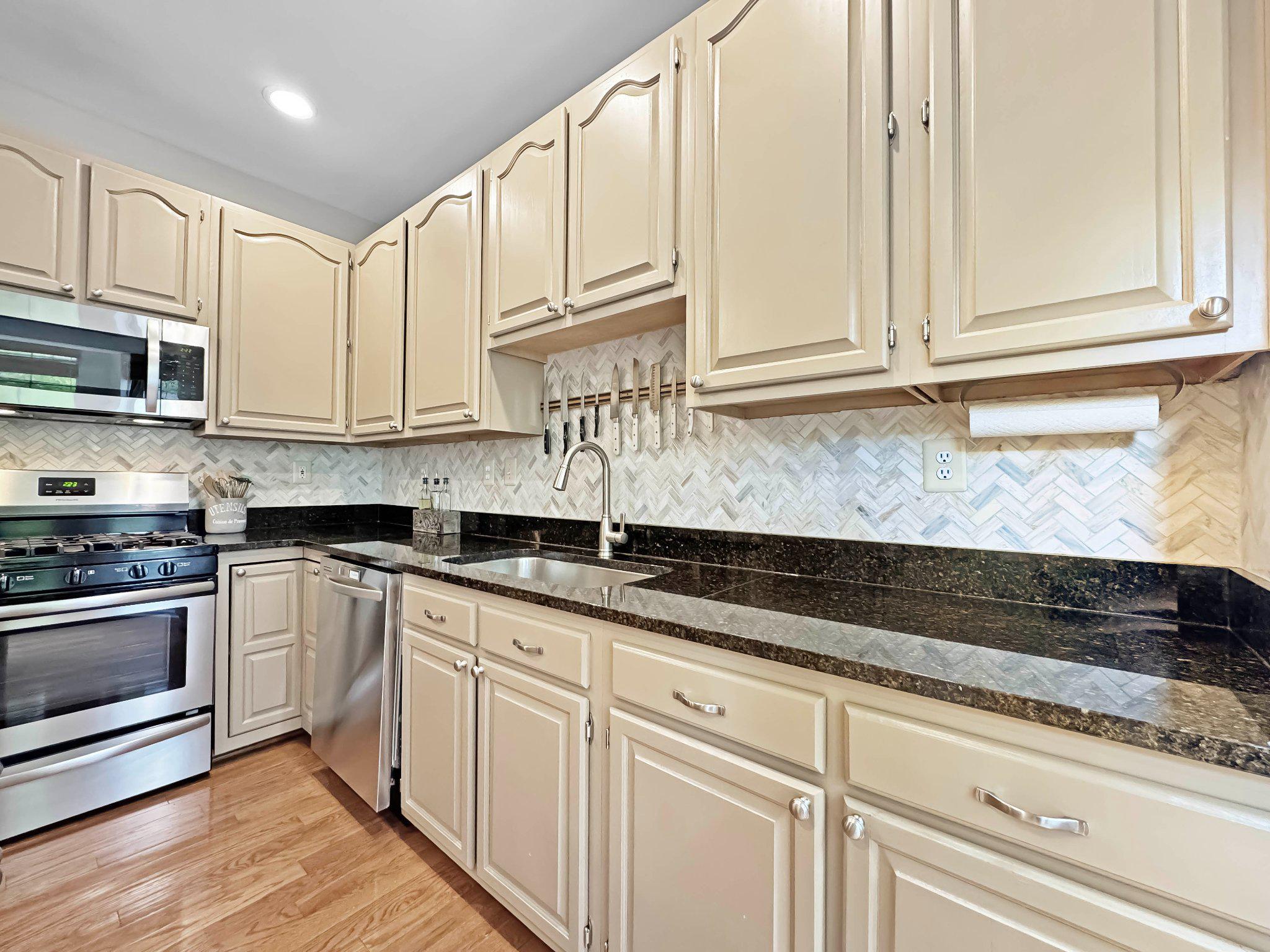47640 Comer Square Sterling, VA 20165 - Photo 9 of 58 a kitchen with granite countertop white cabinets stainless steel appliances and a sink