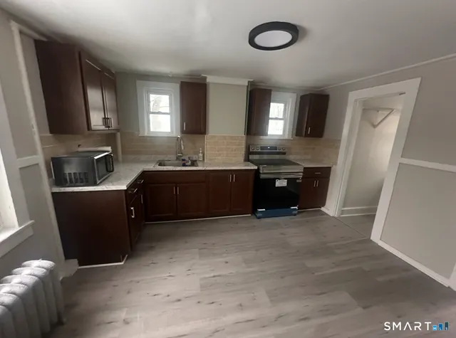 a kitchen with stainless steel appliances granite countertop a sink and a refrigerator