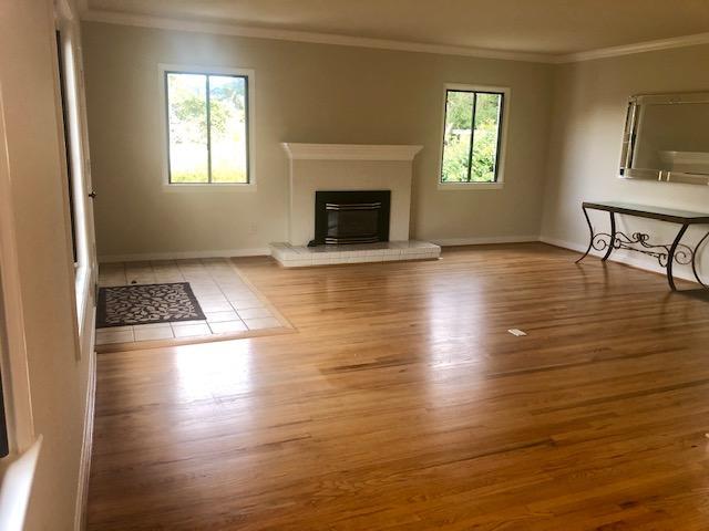121 Soledad Drive Monterey, CA 93940 - Photo 4 of 14 an empty room with wooden floor fireplace and windows