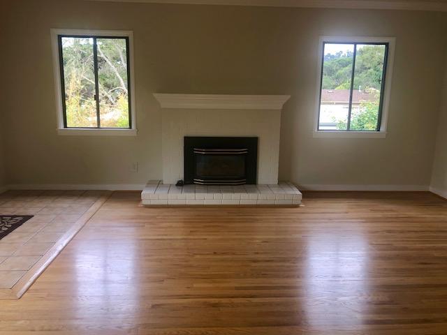 121 Soledad Drive Monterey, CA 93940 - Photo 5 of 14 an empty room with wooden floor a fireplace and windows