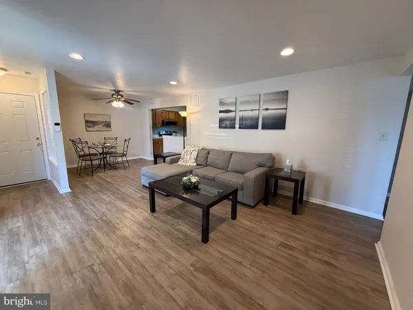 a living room with furniture a flat screen tv and kitchen view
