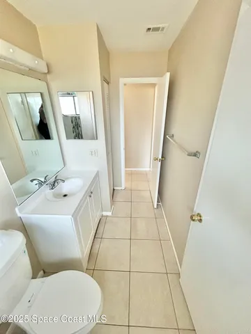 a bathroom with a sink mirror vanity and toilet