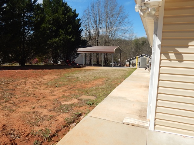 855 Louie Lane Seneca, SC 29678 - Photo 8 of 33 The exterior of the house features light-colored siding and a practical carport.