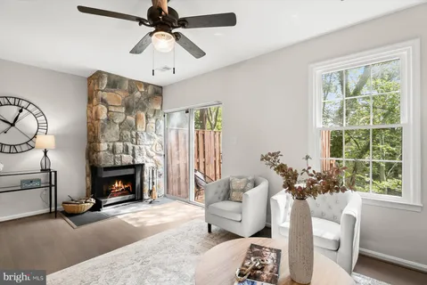 a living room with furniture a fireplace and a chandelier