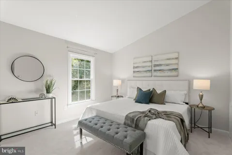 a bedroom with a bed and a dresser next to a window