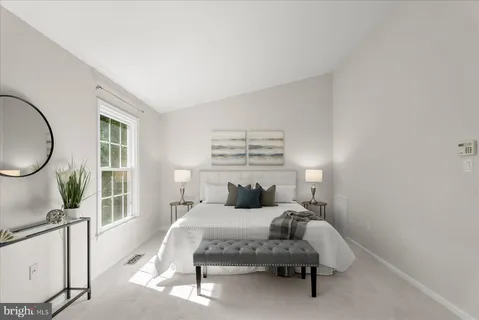 a bedroom with a bed a mirror and a large window
