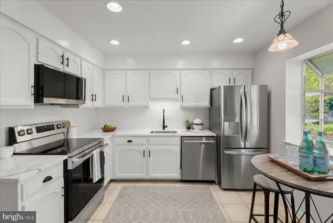 a kitchen with cabinets stainless steel appliances and a window