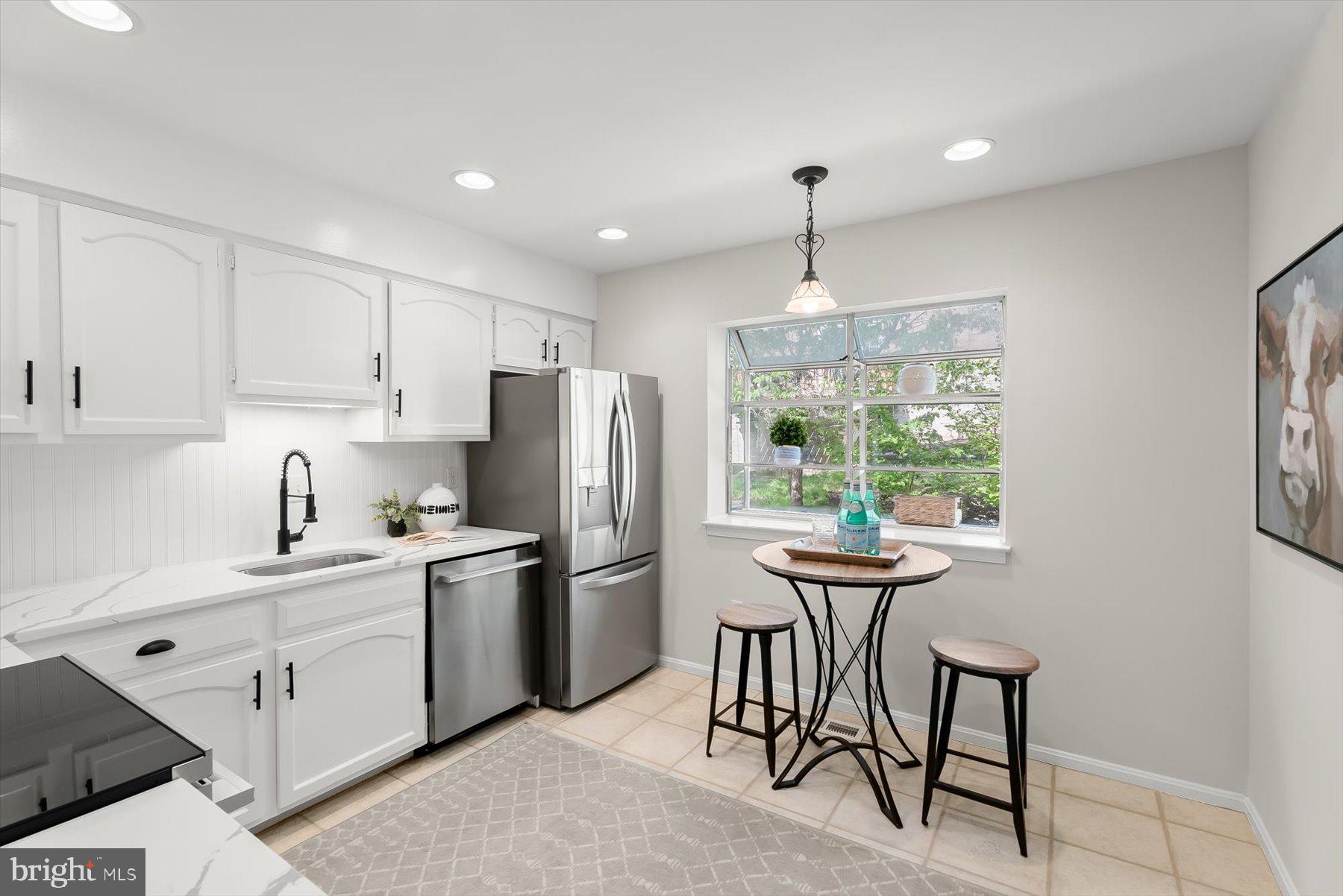 1530 Tanyard Hill Road Gaithersburg, MD 20879 - Photo 6 of 40 a kitchen with stainless steel appliances a dining table chairs stove refrigerator and cabinets